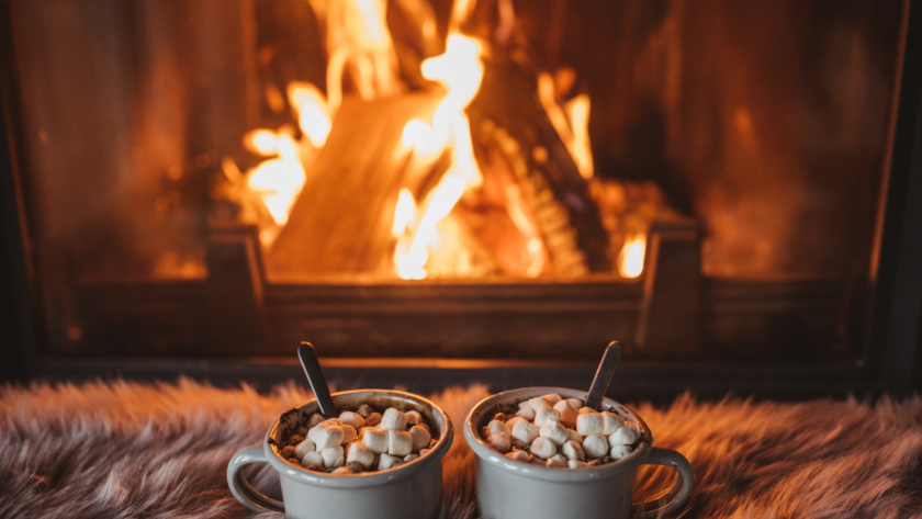life-lately-december-2022-header: Two hot chocolates on a blanket sat in front of a cosy fire.